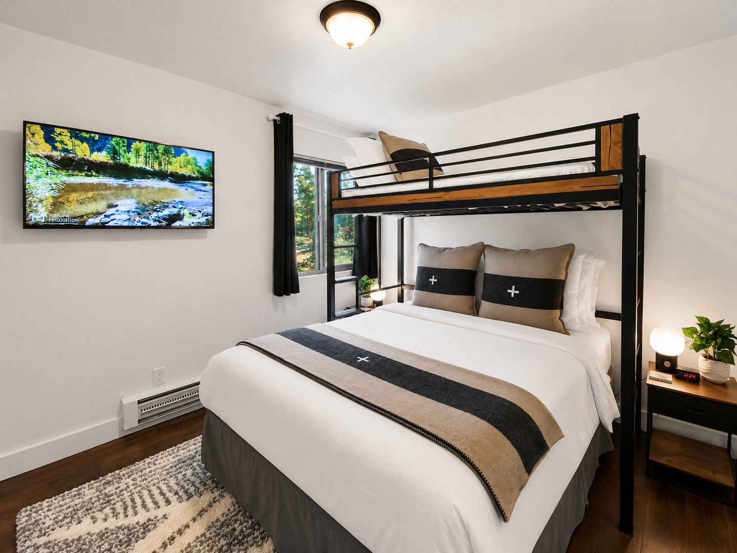 Sink into crisp linens and modern comfort in your bedroom, with a flatscreen TV, bunk above, and peaceful forest views through the window. Perfect for families or friends traveling together.