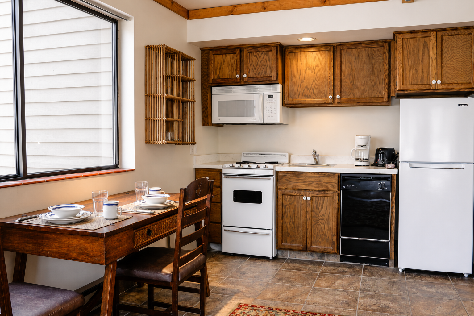 Your fully equipped kitchenette features a stove, microwave, dishwasher, and fridge, with a cozy dining nook by the window for morning coffee or meal prep.