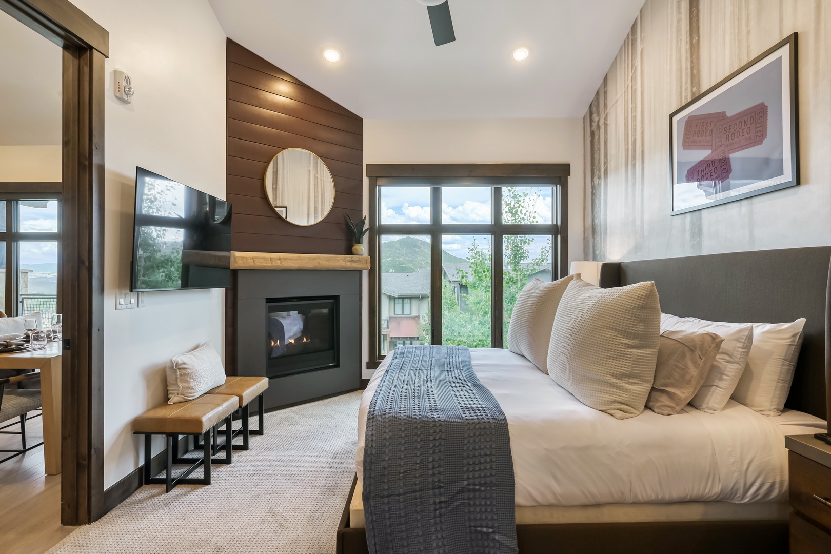 Settle into your cozy mountain retreat with a plush bed, crackling fireplace, and stunning views framing your peaceful escape.