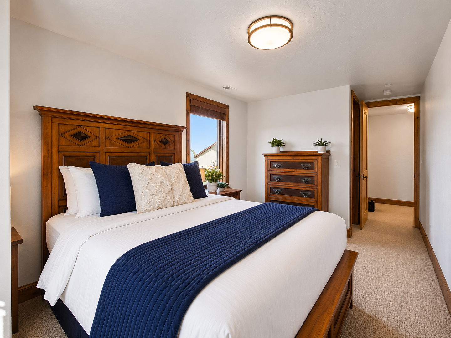 This sun-drenched guest room features a sturdy wood-framed queen bed, plush linens, and dual oversized windows. Enjoy stunning views of the surrounding mountain landscape from the comfort of your room.