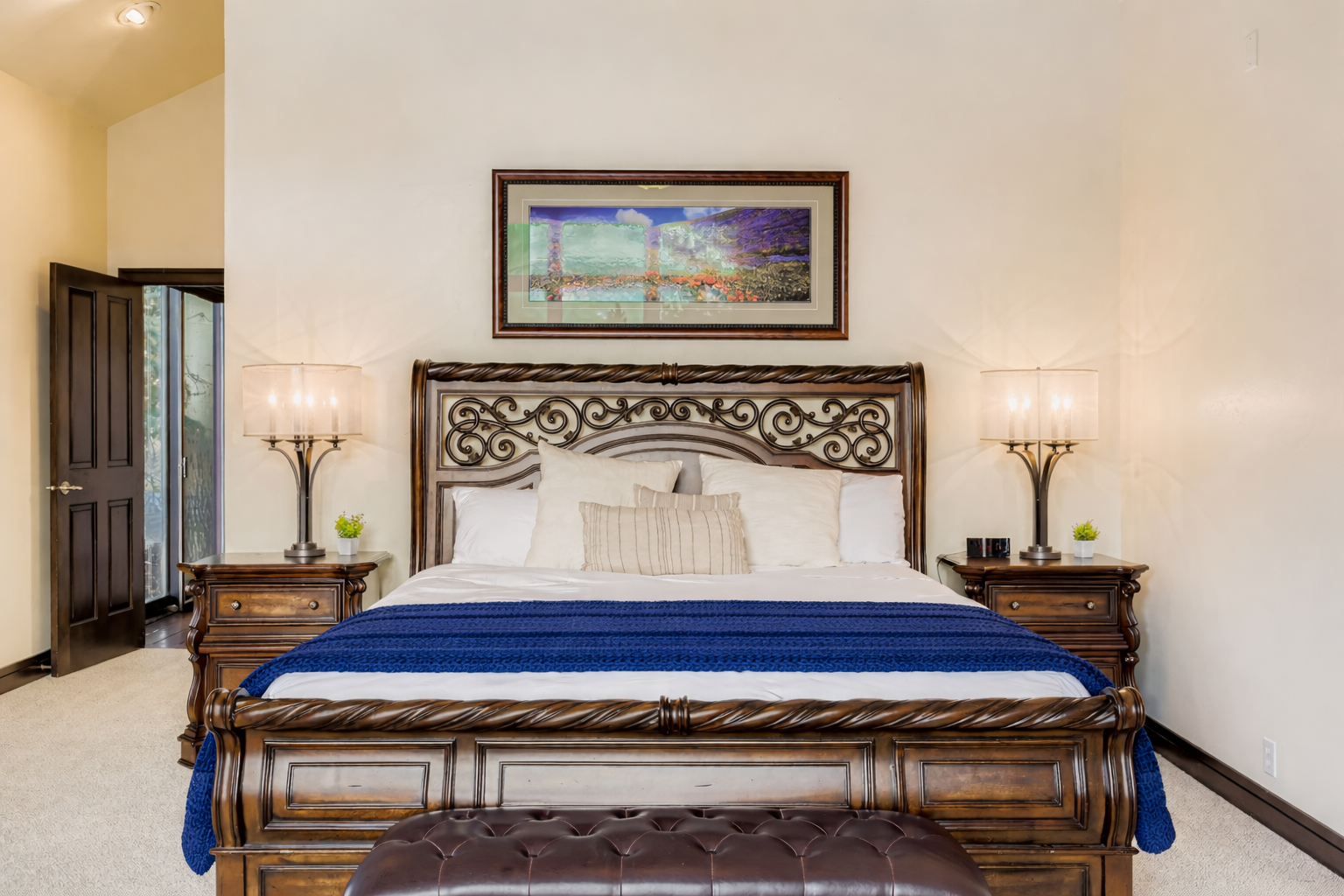 Sink into luxury with ornate wood furnishings, crisp linens, and elegant bedside lamps creating your perfect retreat.