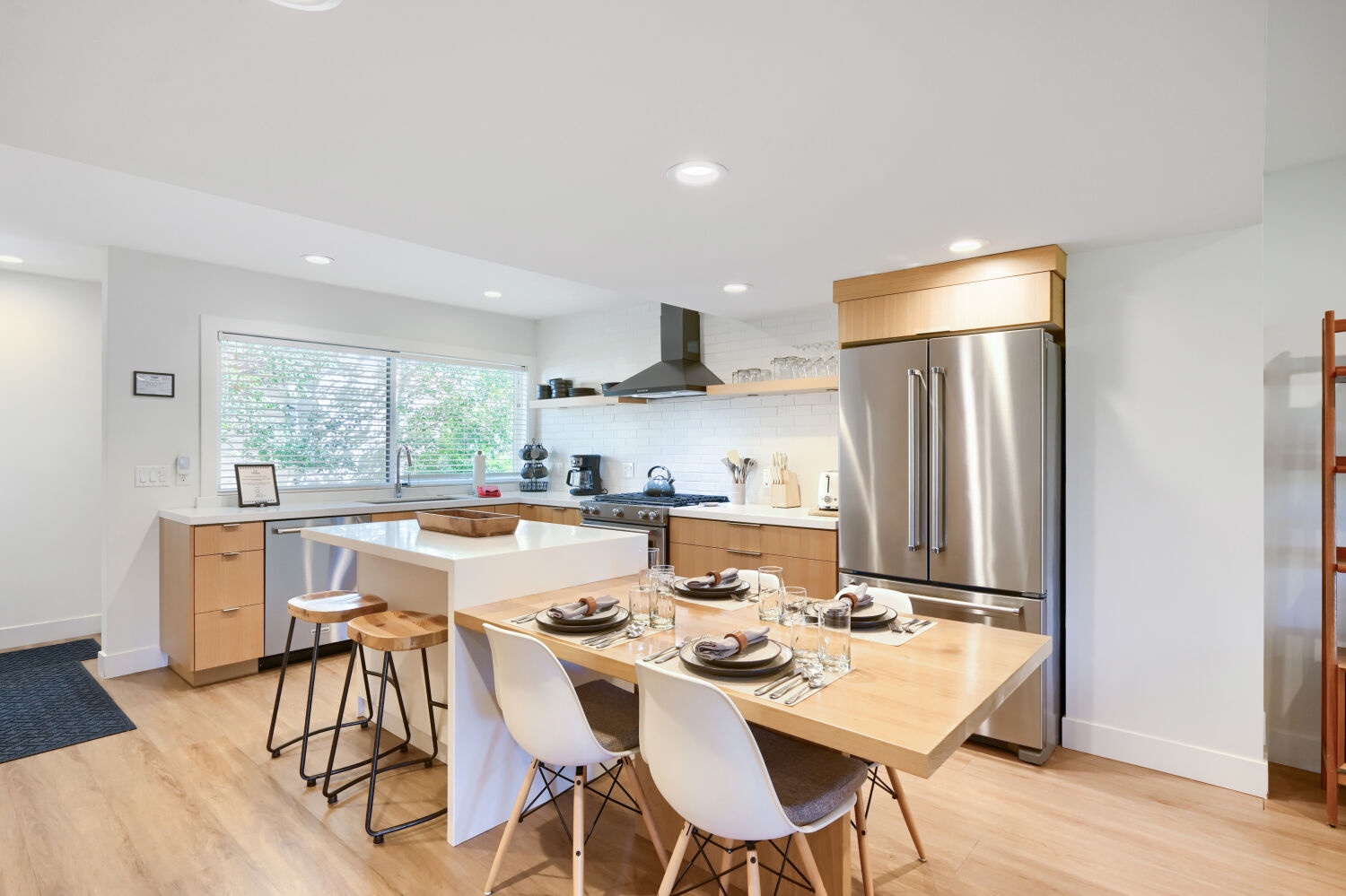 Your modern, open-concept kitchen welcomes you with sleek stainless appliances, warm wood cabinetry, and a bright island where you can cook and dine comfortably in natural light.