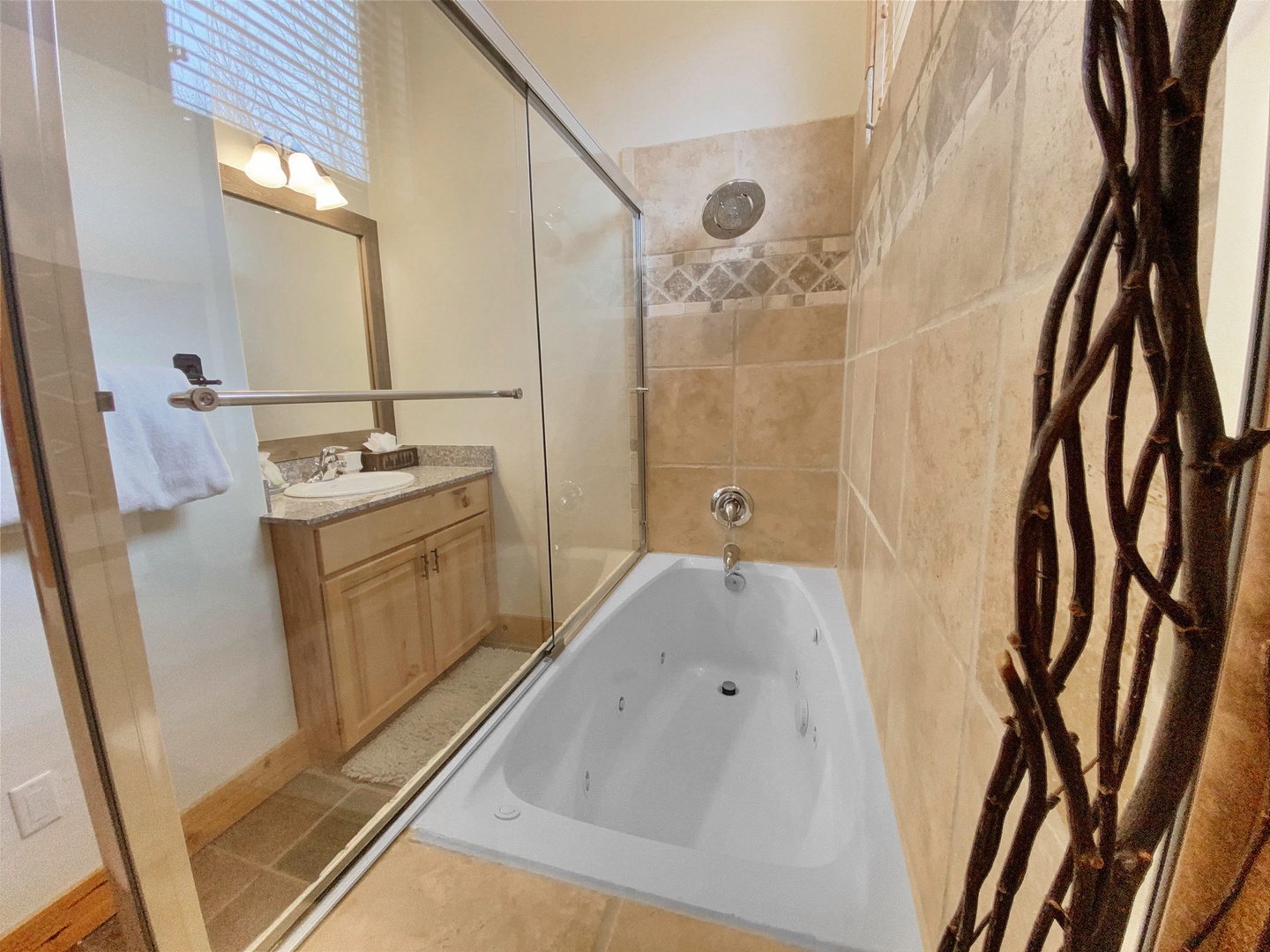 Unwind in your spacious bathroom with a jetted soaking tub, a refreshing walk-in shower, and warm tile details throughout. Soft towels and natural light await your arrival.