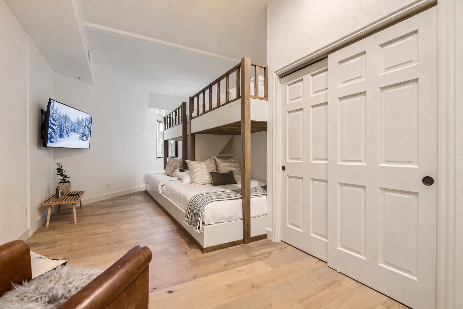 Cozy up in this modern bunk bed setup, perfect for families or groups. Enjoy your own wall-mounted TV while staying organized with spacious closets.