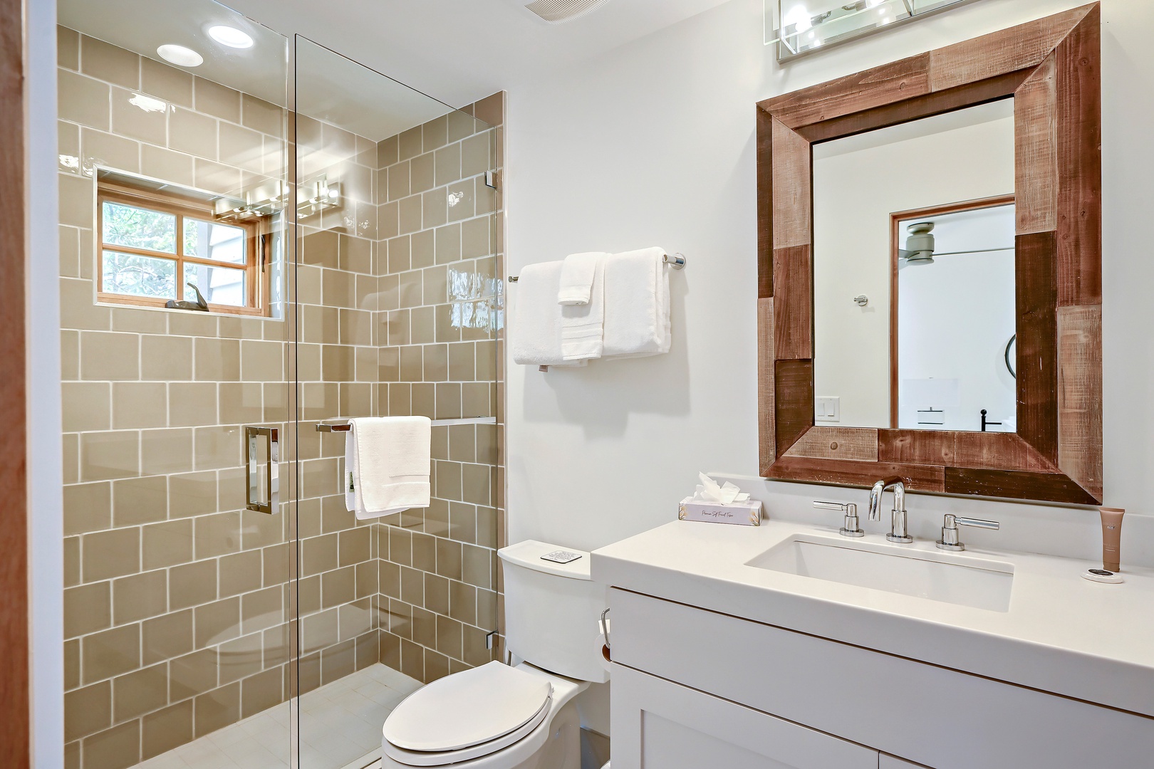 Step into your beautifully appointed bathroom with soft natural light, crisp white linens, and a spacious glass-enclosed shower ready for a refreshing start to your day.