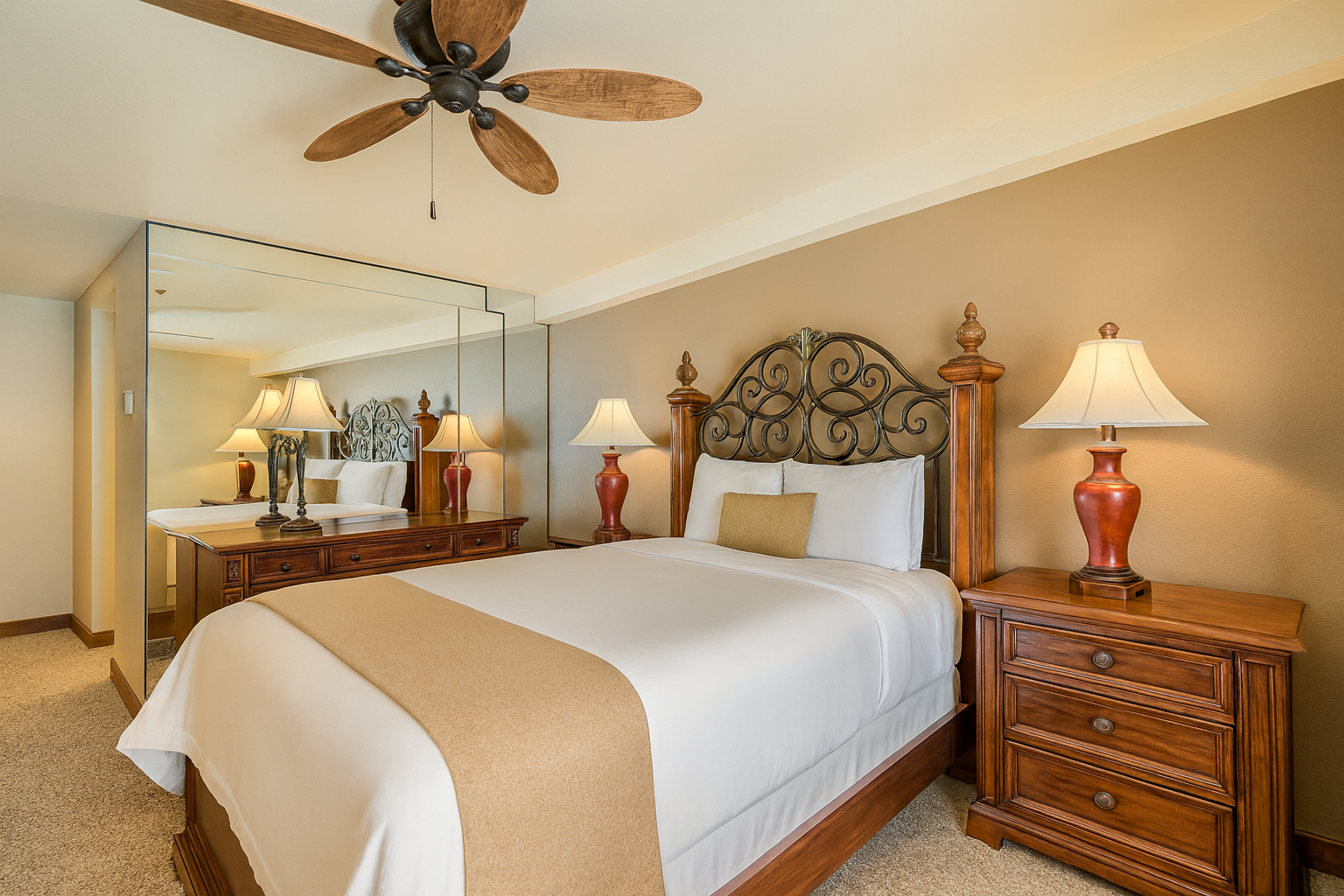 Relax in this warm and inviting bedroom featuring a plush queen bed, elegant wood furnishings, and cozy tan accents. Soft lighting, mirrored walls, and a classic wrought-iron headboard create a serene retreat after exploring Park City’s ski slopes.