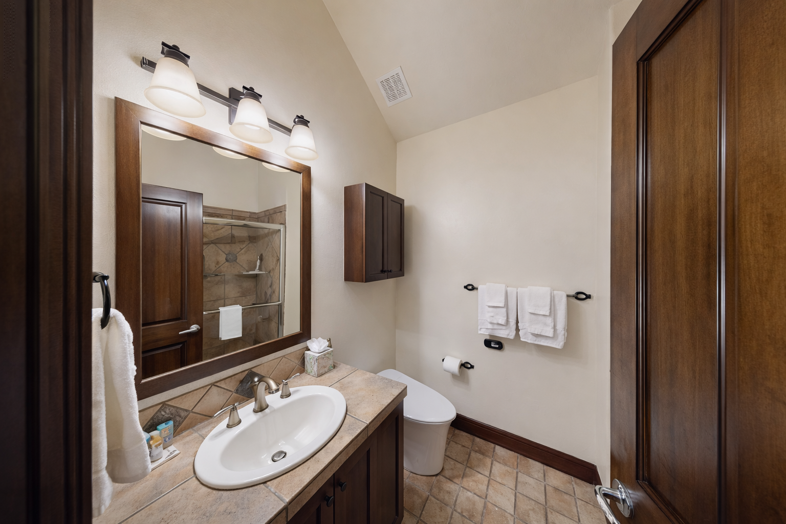 Step into your beautifully appointed bathroom with warm wood finishes and thoughtful amenities for your comfort.