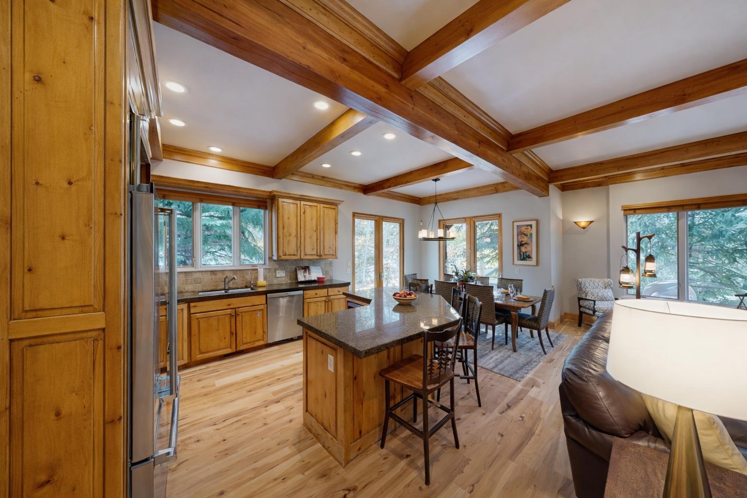 Step into your mountain retreat where rich wood beams frame the open-concept space, connecting your gourmet kitchen to cozy dining and living areas.