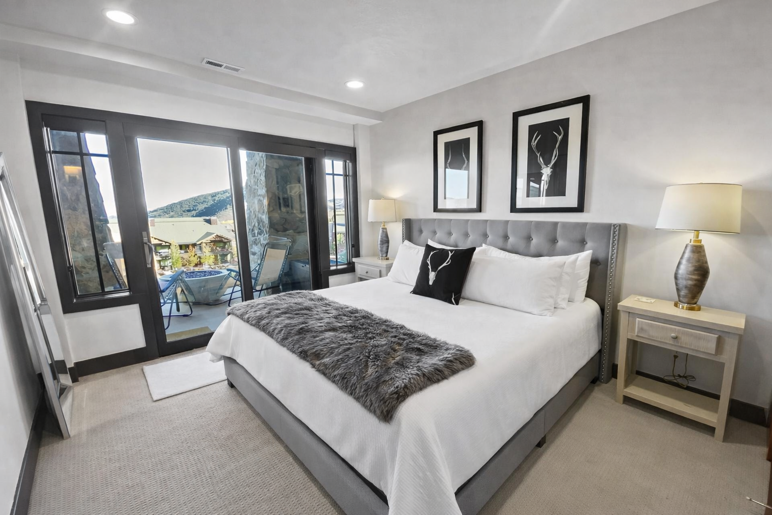 Sink into luxury in your elegantly appointed bedroom featuring plush bedding, modern furnishings, and stunning views through floor-to-ceiling windows.