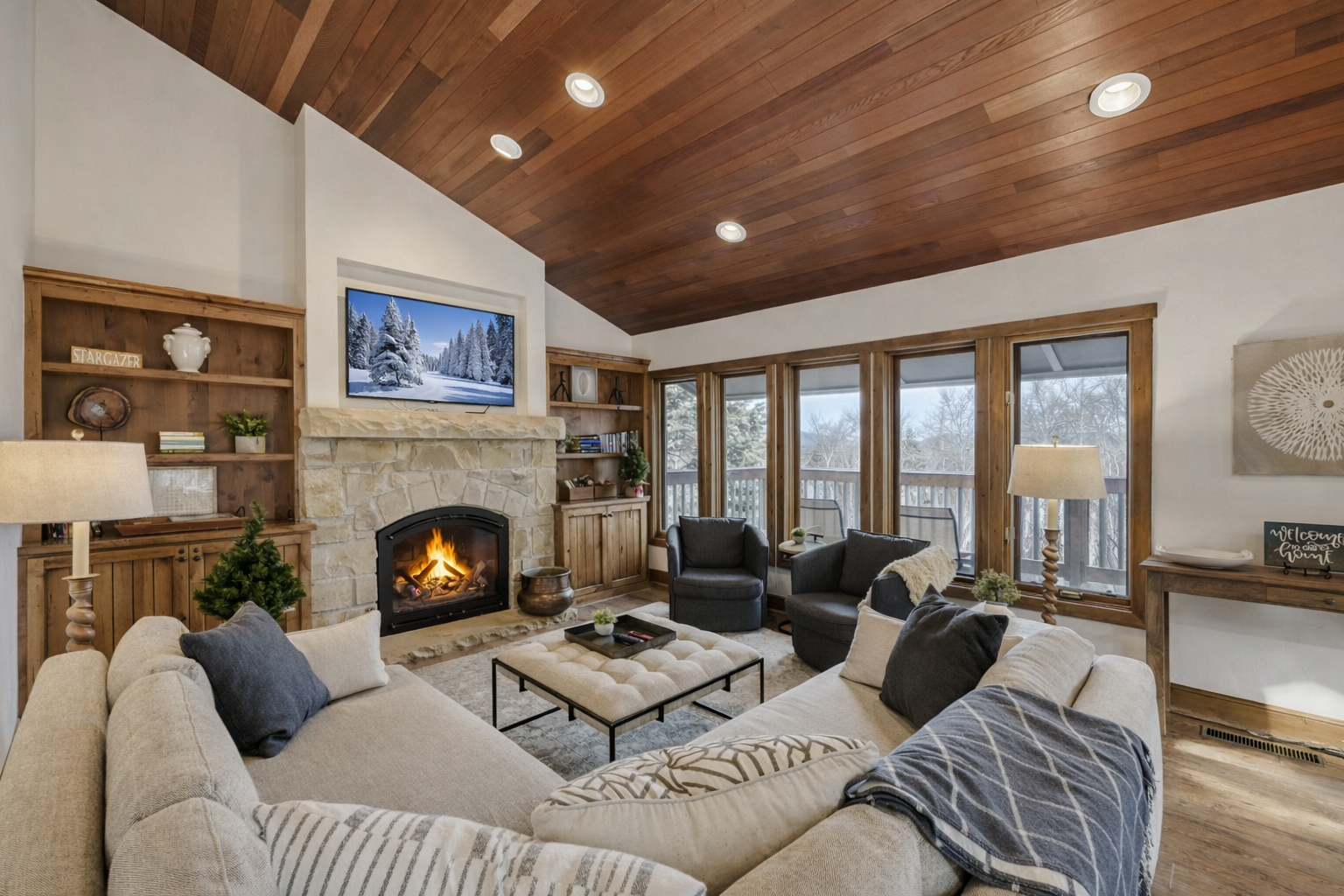 Sink into plush seating by your crackling fireplace, where warm wood tones and mountain views create the perfect winter retreat.