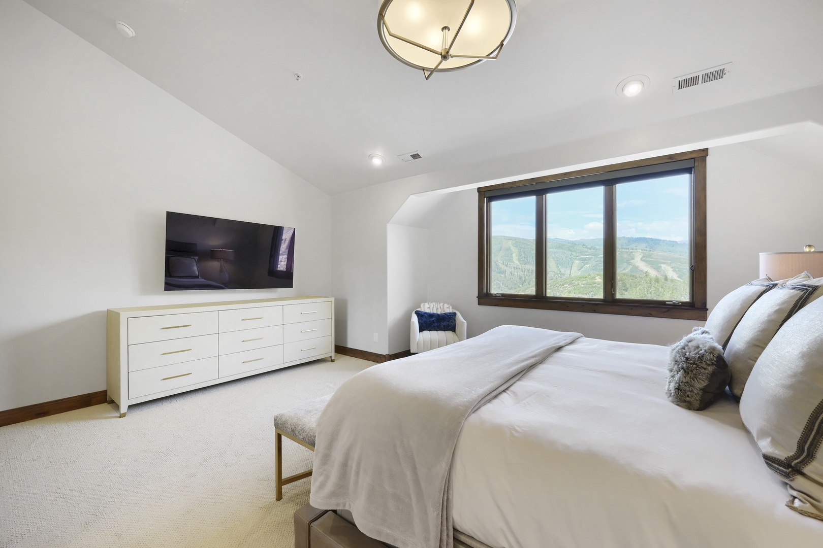 Wake to sweeping mountain views framed by your bedroom window. Soft linens, a serene palette, and vaulted ceilings create your perfect escape.