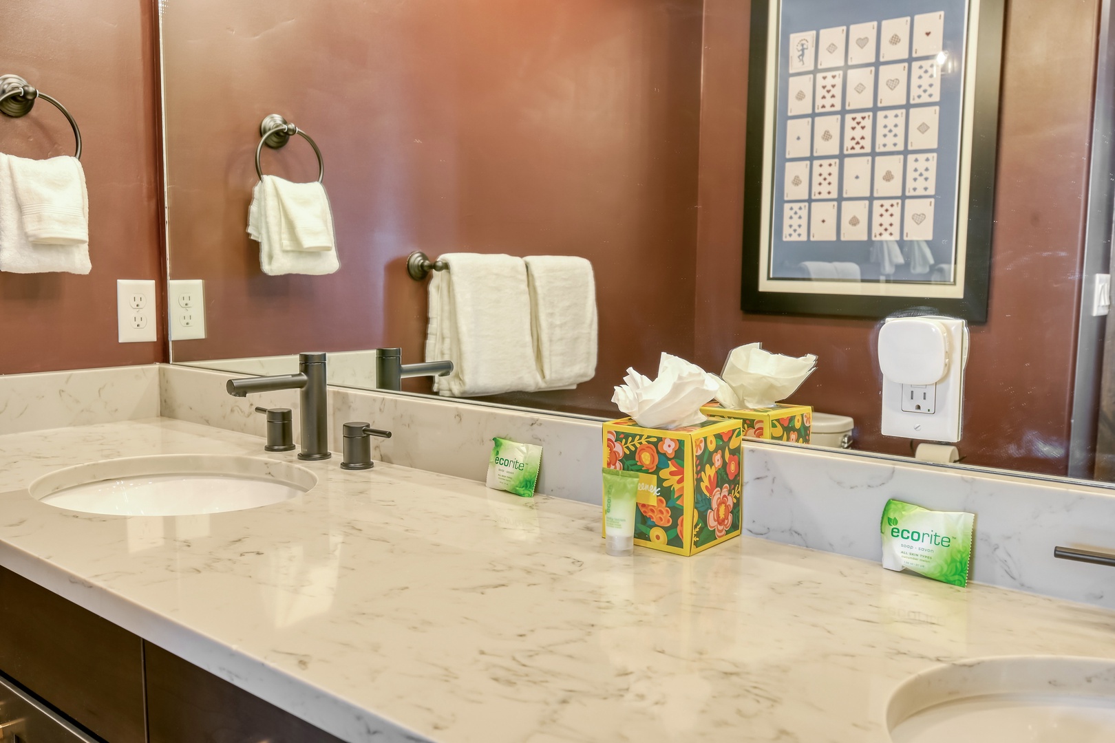 Your private bathroom features dual sinks with elegant marble countertops, plush towels, and thoughtful eco-friendly amenities for your comfort.