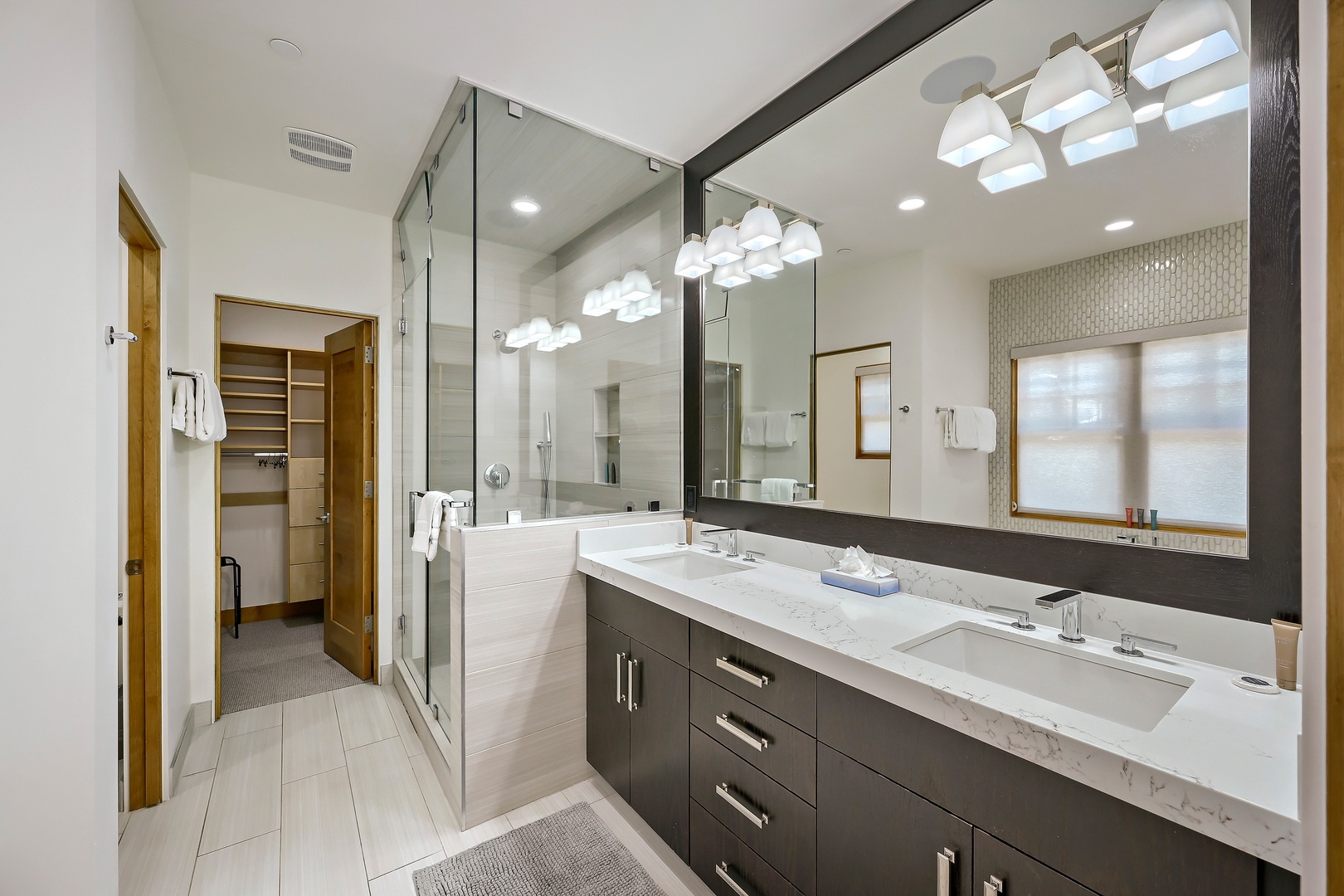 Sleek modern bathroom with dual vanity, walk-in shower, and plenty of natural light—your private retreat awaits.