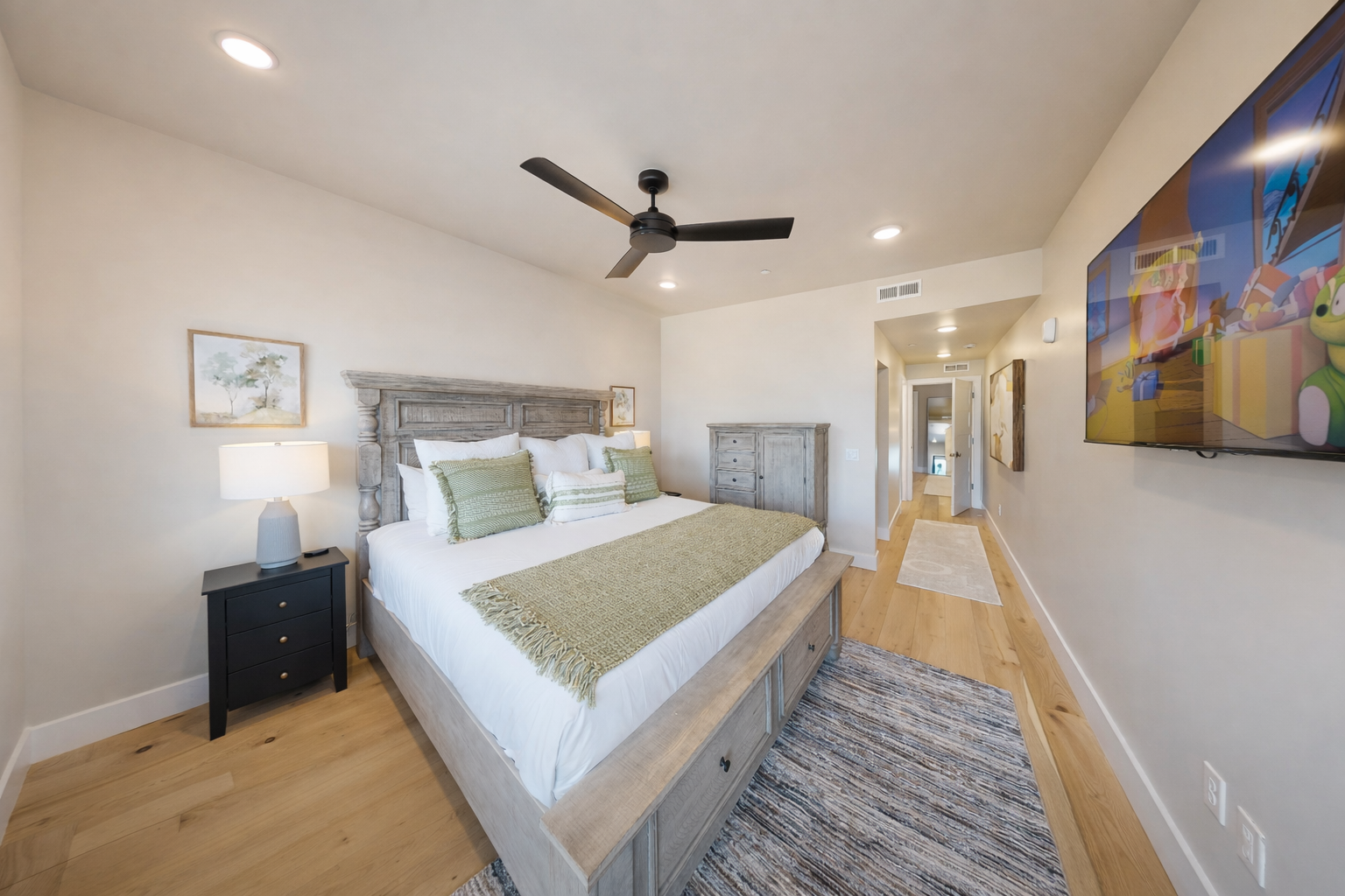 Relax in this bright, modern bedroom featuring a plush king bed and sleek wooden accents. A serene mountain retreat with large windows—perfect for your next Park City adventure.