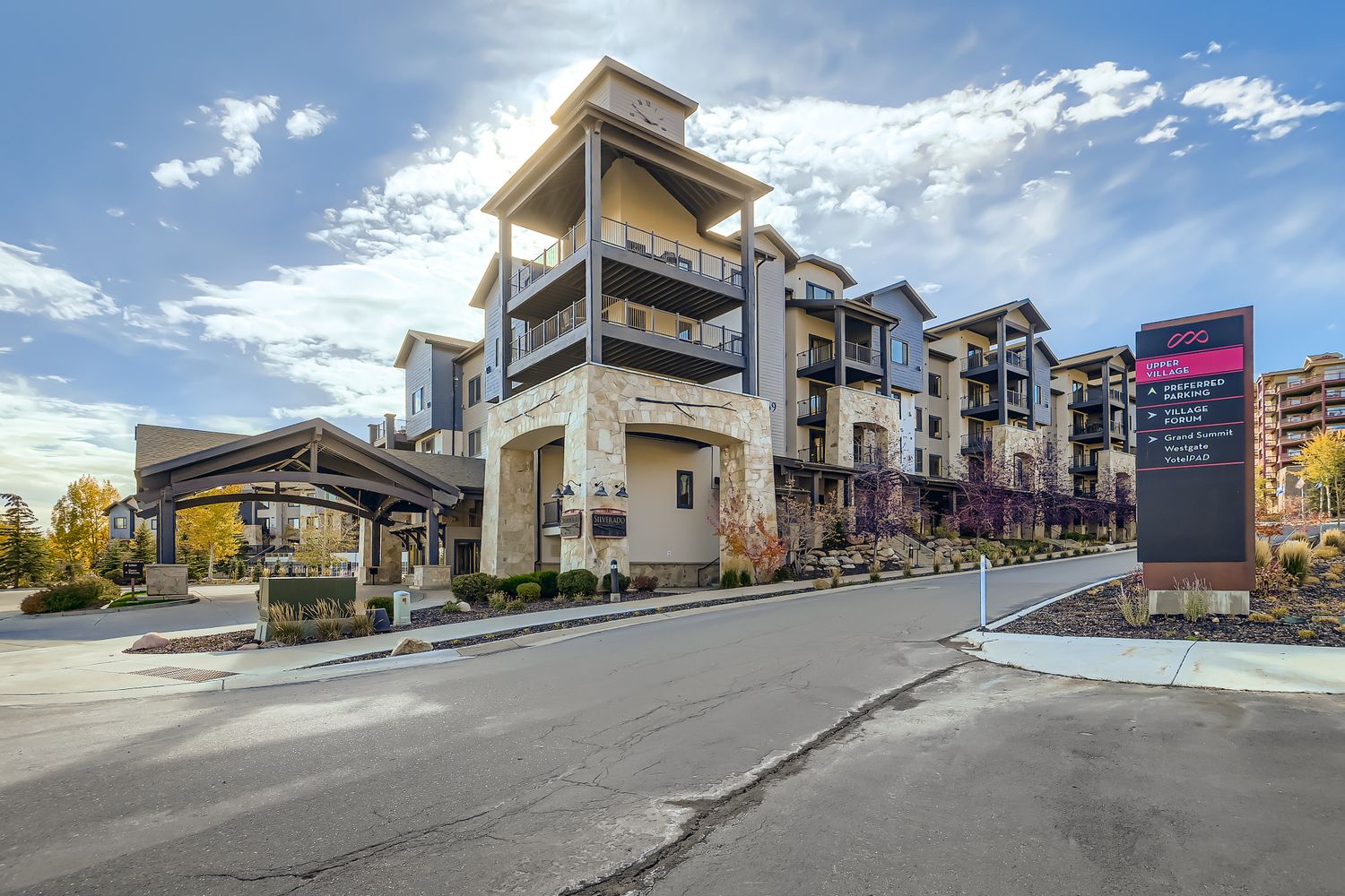 Modern multi-story property with stone accents and professional signage, located in a well-maintained residential area.