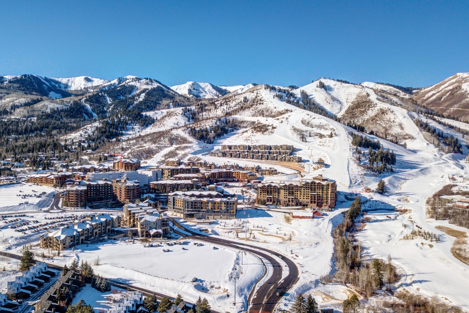 Spectacular winter mountain resort village nestled in snow-covered peaks with direct ski slope access.