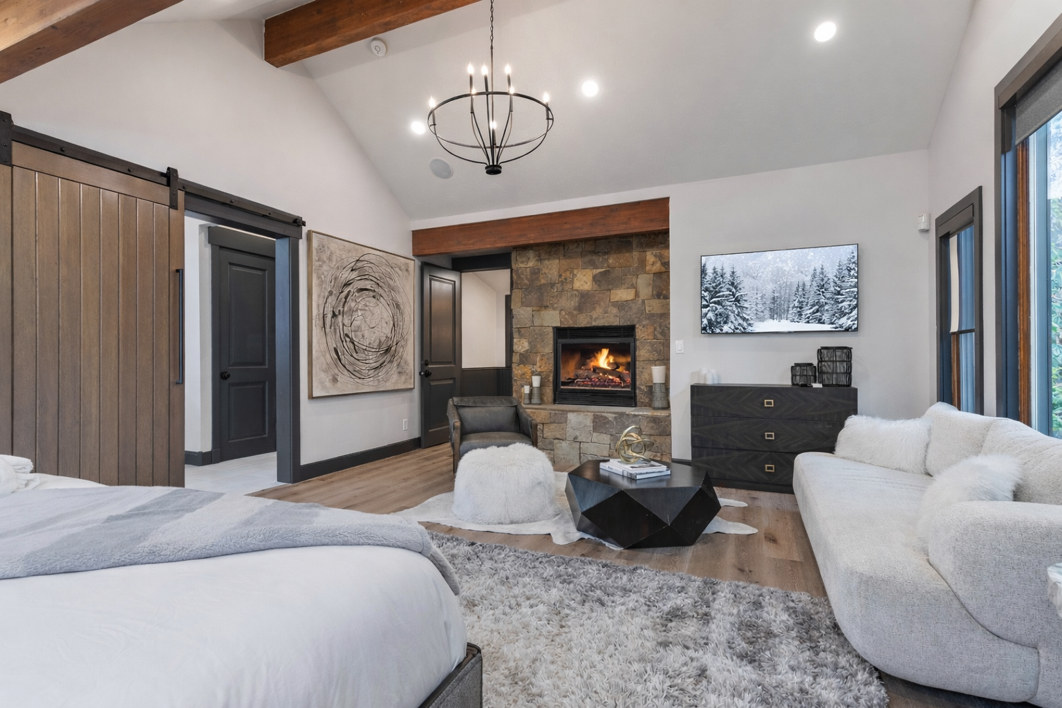 Relax in this elegant suite where you'll find a cozy fireplace, plush furnishings, and rustic barn doors creating the perfect mountain retreat atmosphere.