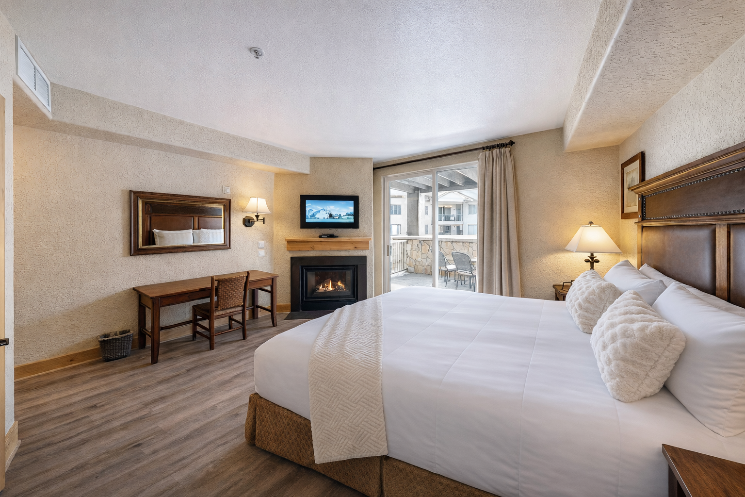 Unwind in this serene bedroom featuring a plush king-sized bed and warm wood accents. Step through sliding doors onto your private balcony to enjoy fresh air and stunning mountain views.