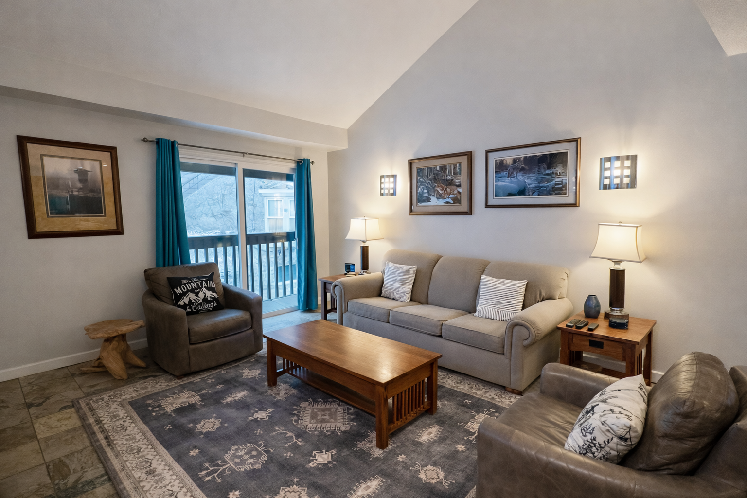 Cozy mountain living room with a stone fireplace, comfy sofa, and balcony access.