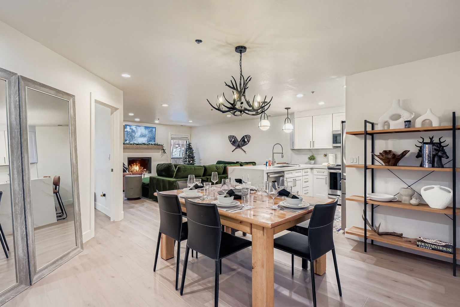 Elegant open-concept living space where you can gather around the beautiful dining table, relax by the cozy fireplace, and cook in the fully equipped modern kitchen.