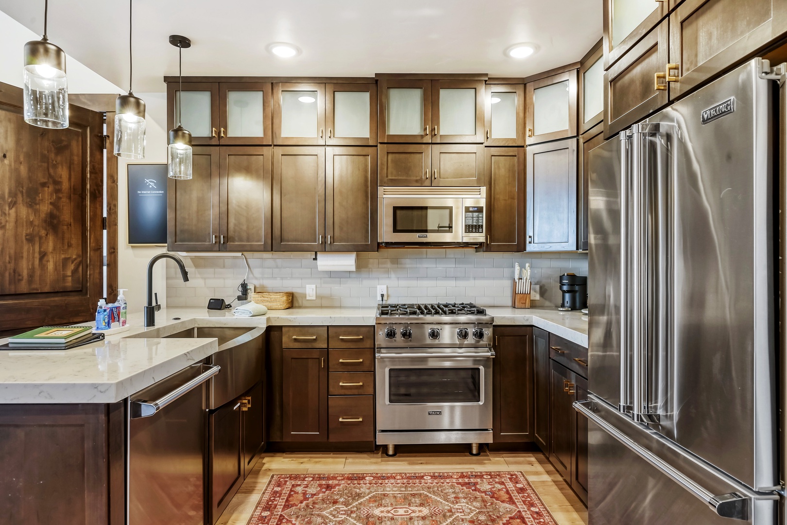 Your chef-ready kitchen features stainless steel appliances, a gas range, marble countertops, rich wood cabinetry, and stylish pendant lighting—everything you need for memorable meals together.