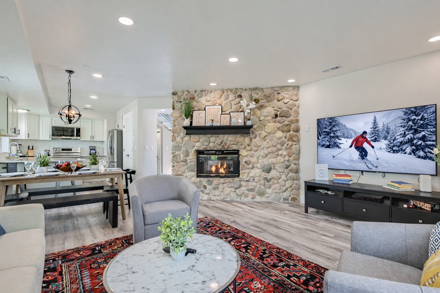 Relax by your stone fireplace while enjoying your open-concept living space with modern kitchen and cozy seating area.