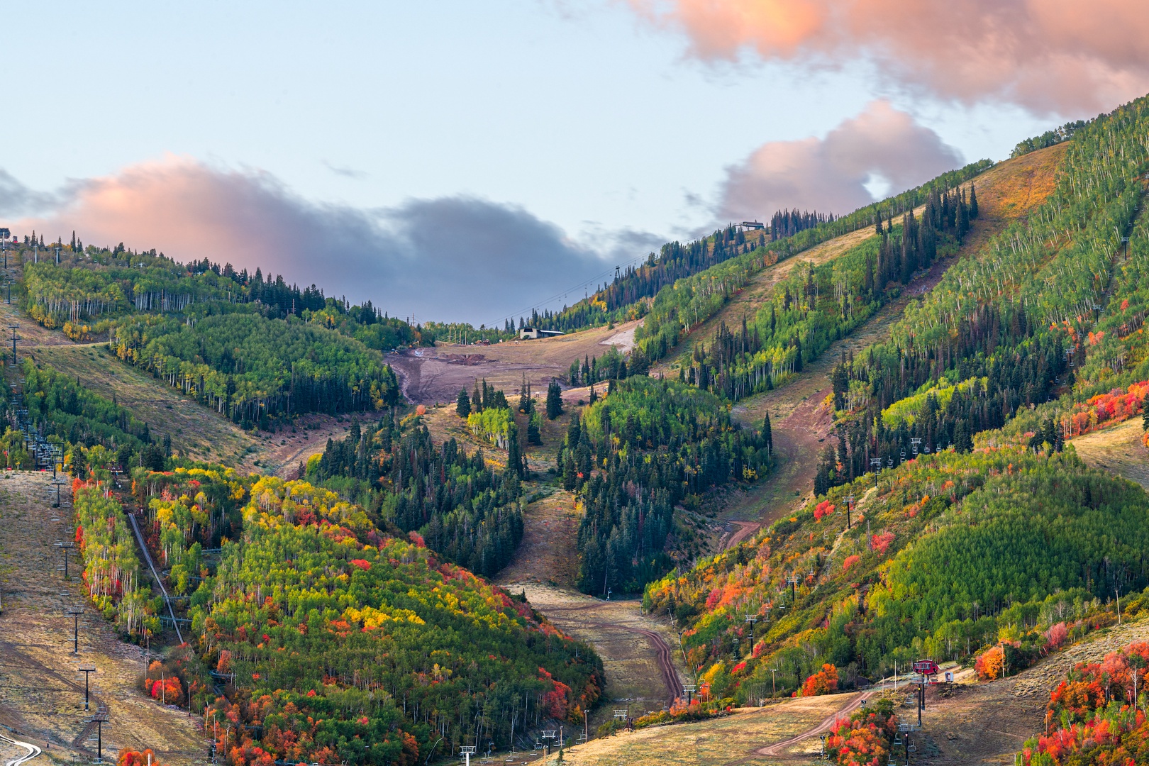 Mountain valley displays brilliant autumn colors with golden aspens and vibrant foliage creating a stunning seasonal landscape.