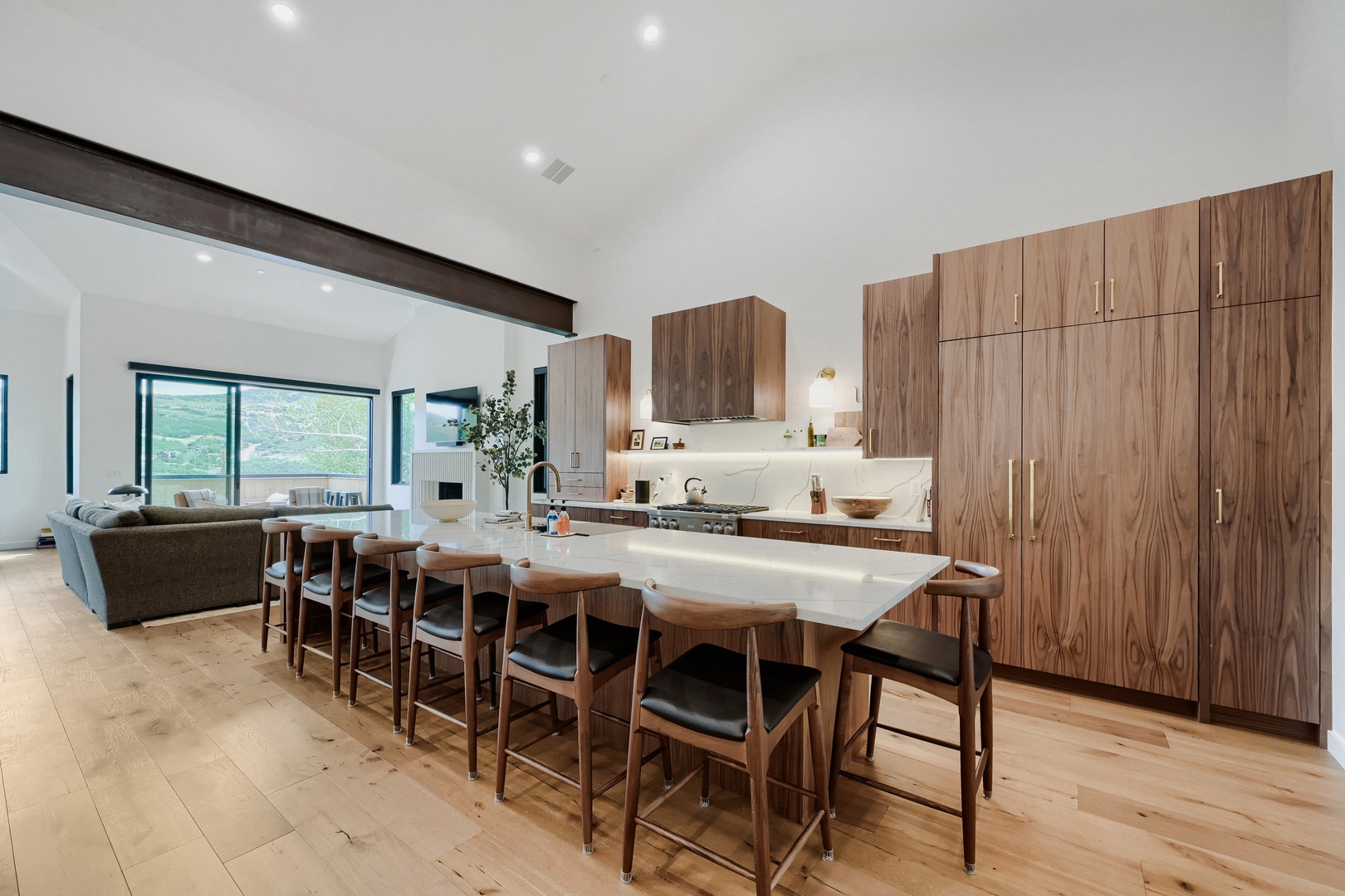 Gather your group at the expansive island with seating for ten, perfectly positioned to enjoy the open flow and scenic mountain views through the living room windows.