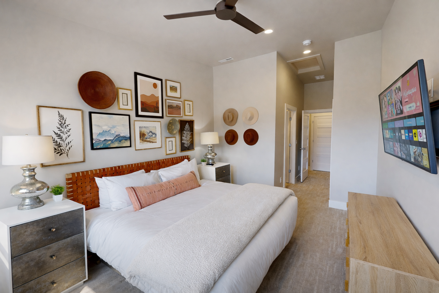 Drift off in your stylish sanctuary with crisp linens, curated art, and a gentle ceiling fan creating the perfect breeze for restful nights.