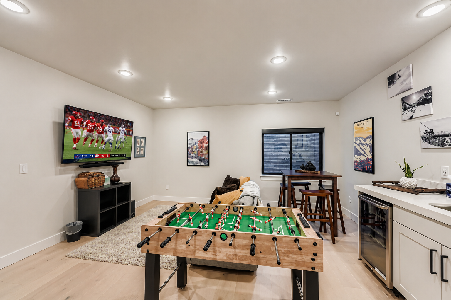 Your game room features a sleek wet bar with sink and dishwasher, perfect for refreshments during foosball tournaments and entertainment.