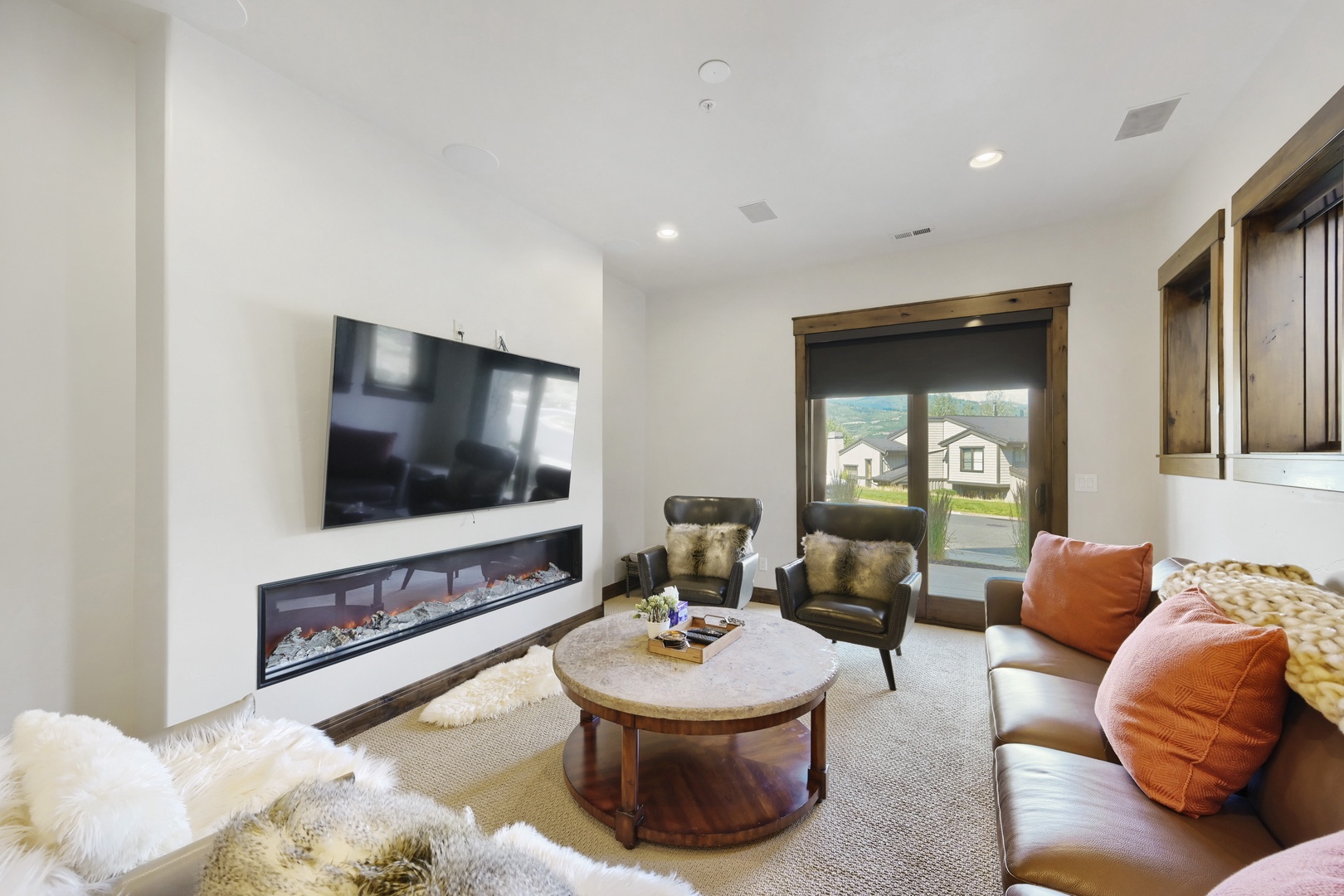 Sink into plush leather seating and warm up by the modern fireplace in your private living room. Natural light streams through the windows, creating a cozy retreat perfect for relaxing evenings.