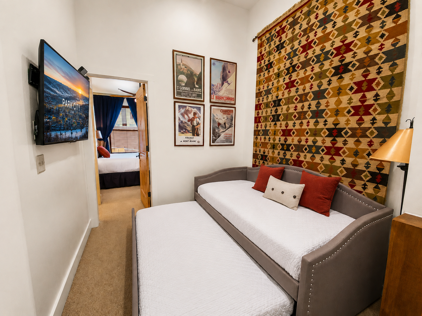 Unwind in your cozy bedroom featuring a comfortable bed, vibrant décor, and entertainment at your fingertips—perfect for restful nights after mountain adventures.