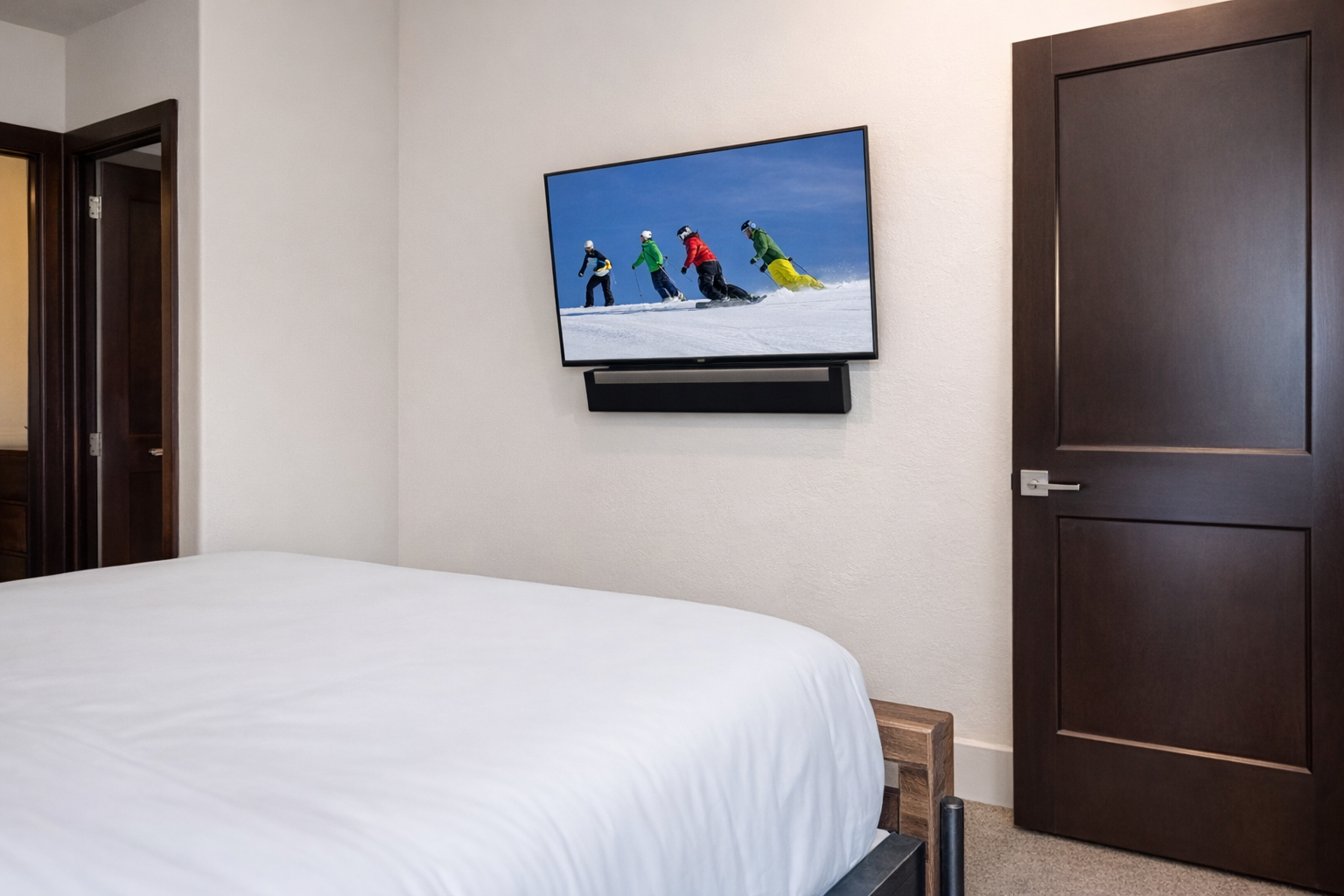 Unwind in your cozy bedroom with plush bedding and wall-mounted TV for your favorite shows after mountain adventures.