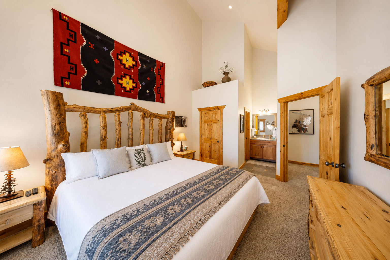 Sink into crisp white linens in your rustic mountain bedroom, where handcrafted log furniture and warm wood tones create a cozy, welcoming retreat after your day's adventures.