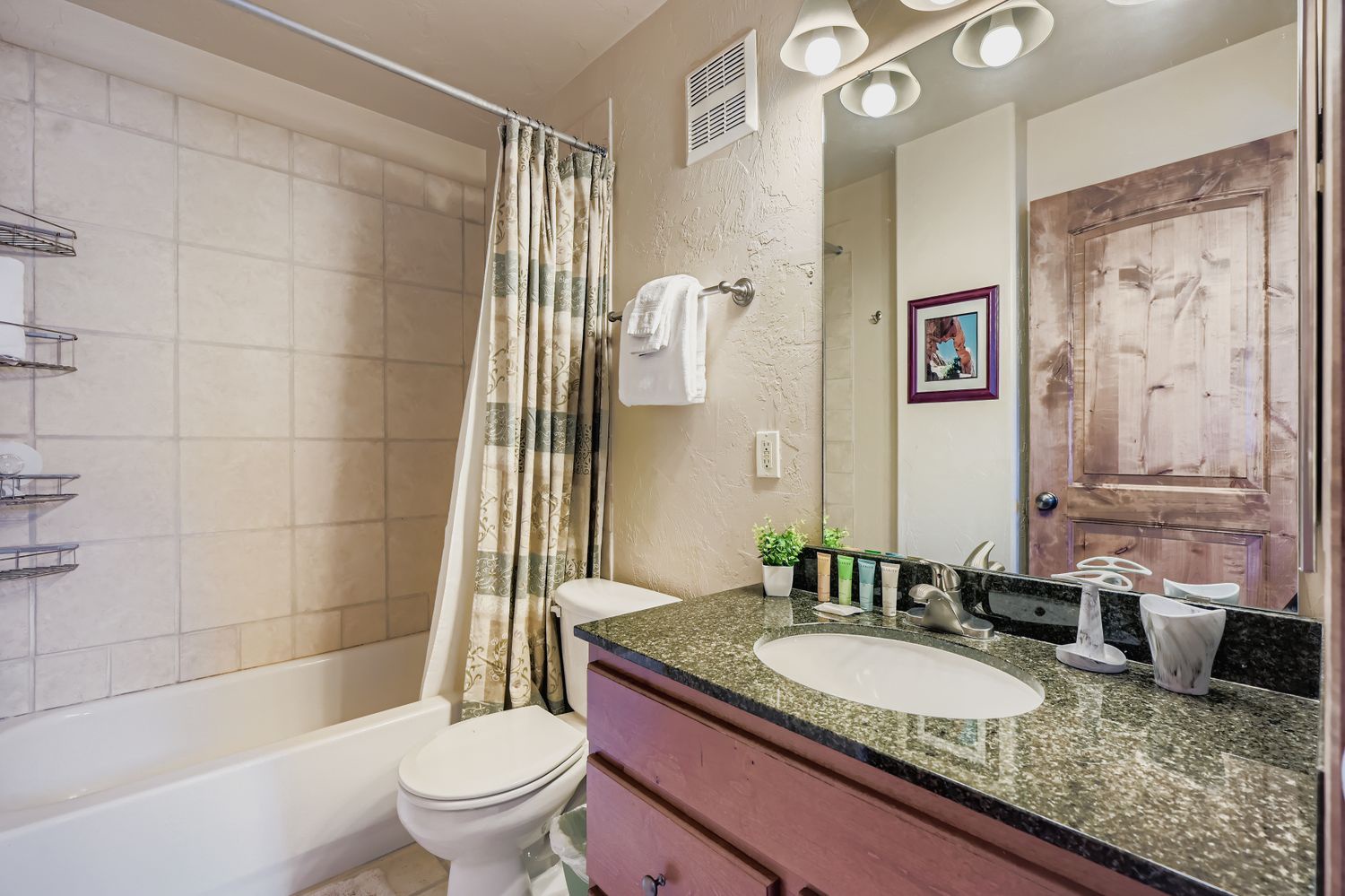Refresh and unwind in your spacious bathroom featuring a soaking tub, granite countertops, and warm lighting for your comfort.