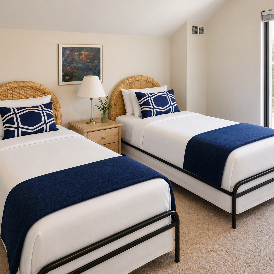 Relax in your cozy bedroom featuring twin beds with plush linens, natural wicker headboards, and coastal-inspired decor—perfect for restful nights.