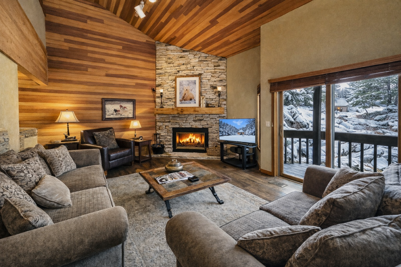 Cozy up in your mountain retreat with crackling fireplace, plush seating, and snowy views through panoramic windows.