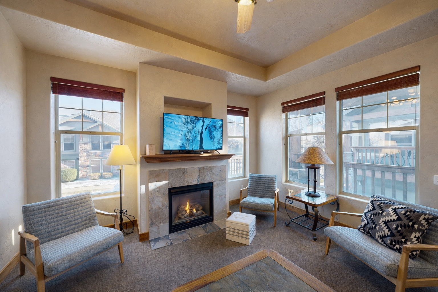 Cozy up by the fireplace while watching your favorite shows in this inviting living space with comfortable seating and warm natural light.