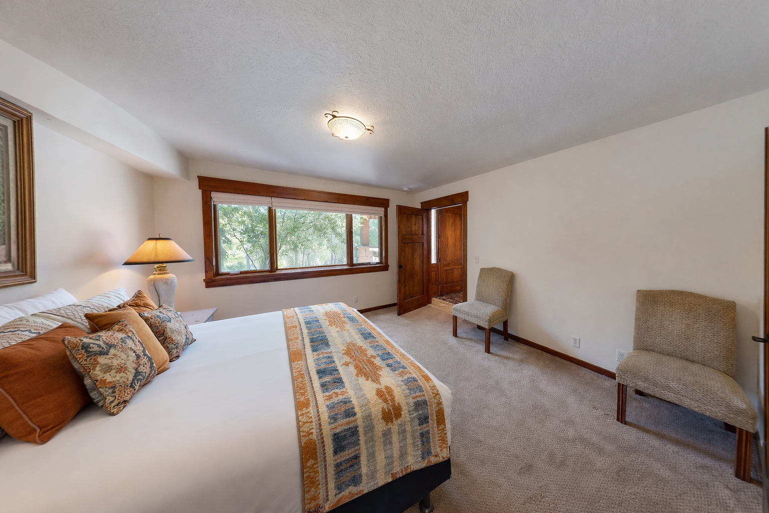 Settle into your comfortable bedroom with warm wood accents and peaceful garden views through the large window.