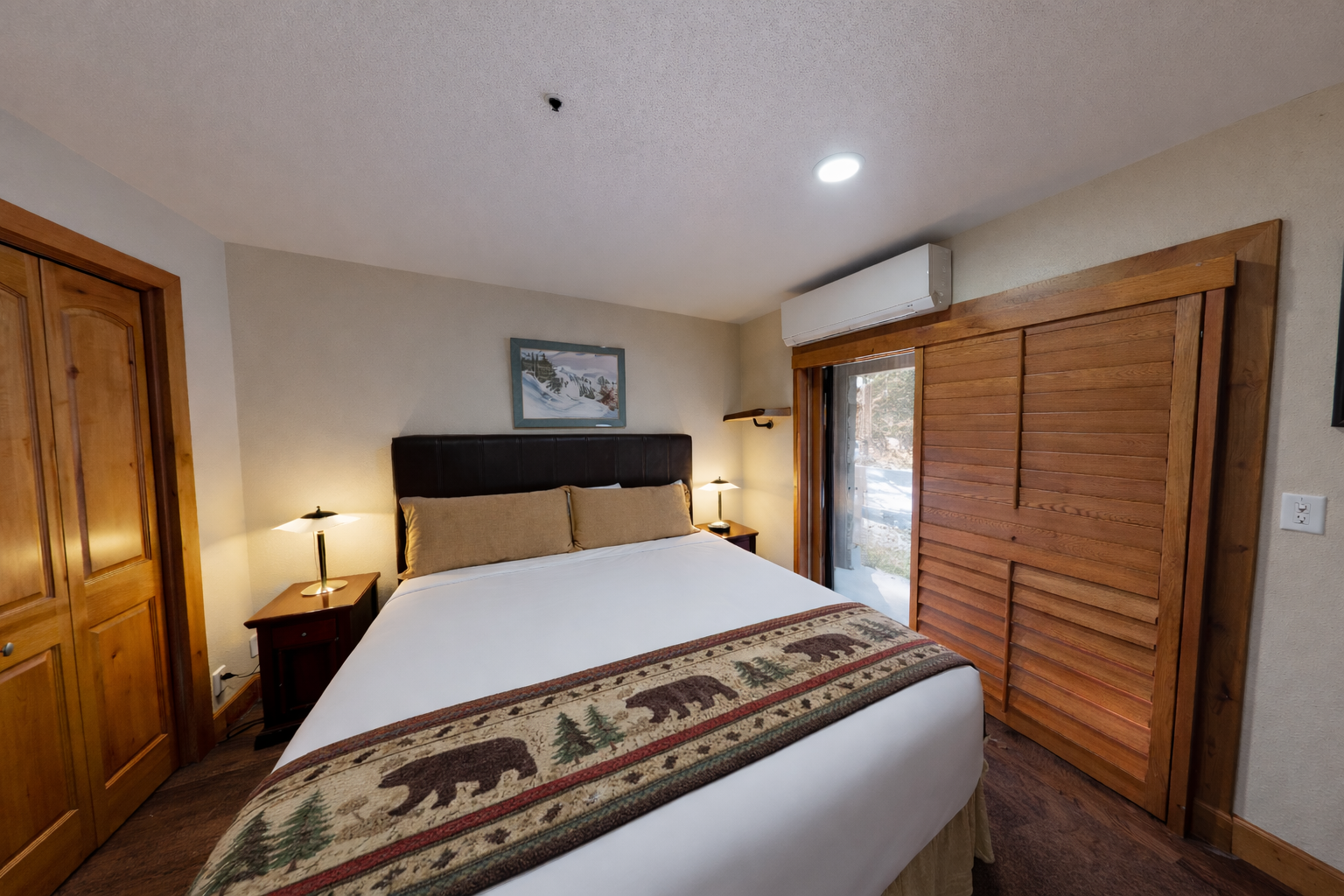 Drift off in your cozy mountain bedroom with warm wood tones, soft bedside lighting, and rustic charm for the perfect alpine retreat.