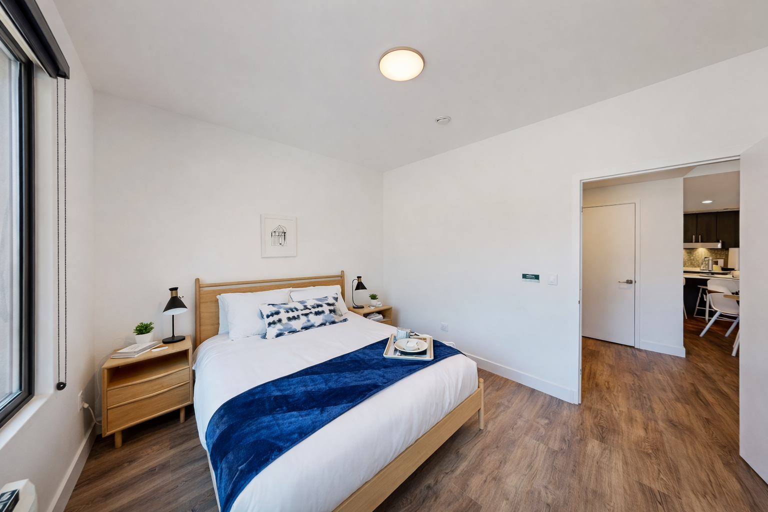 Sink into crisp white linens and wake up naturally in your bright, modern bedroom with beautiful hardwood floors and city views.