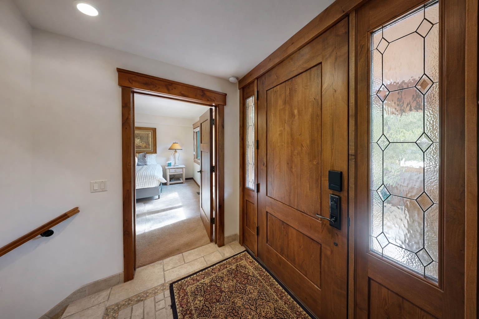 Step through elegant wood doors into your welcoming entryway, where beautiful stained glass creates colorful patterns.