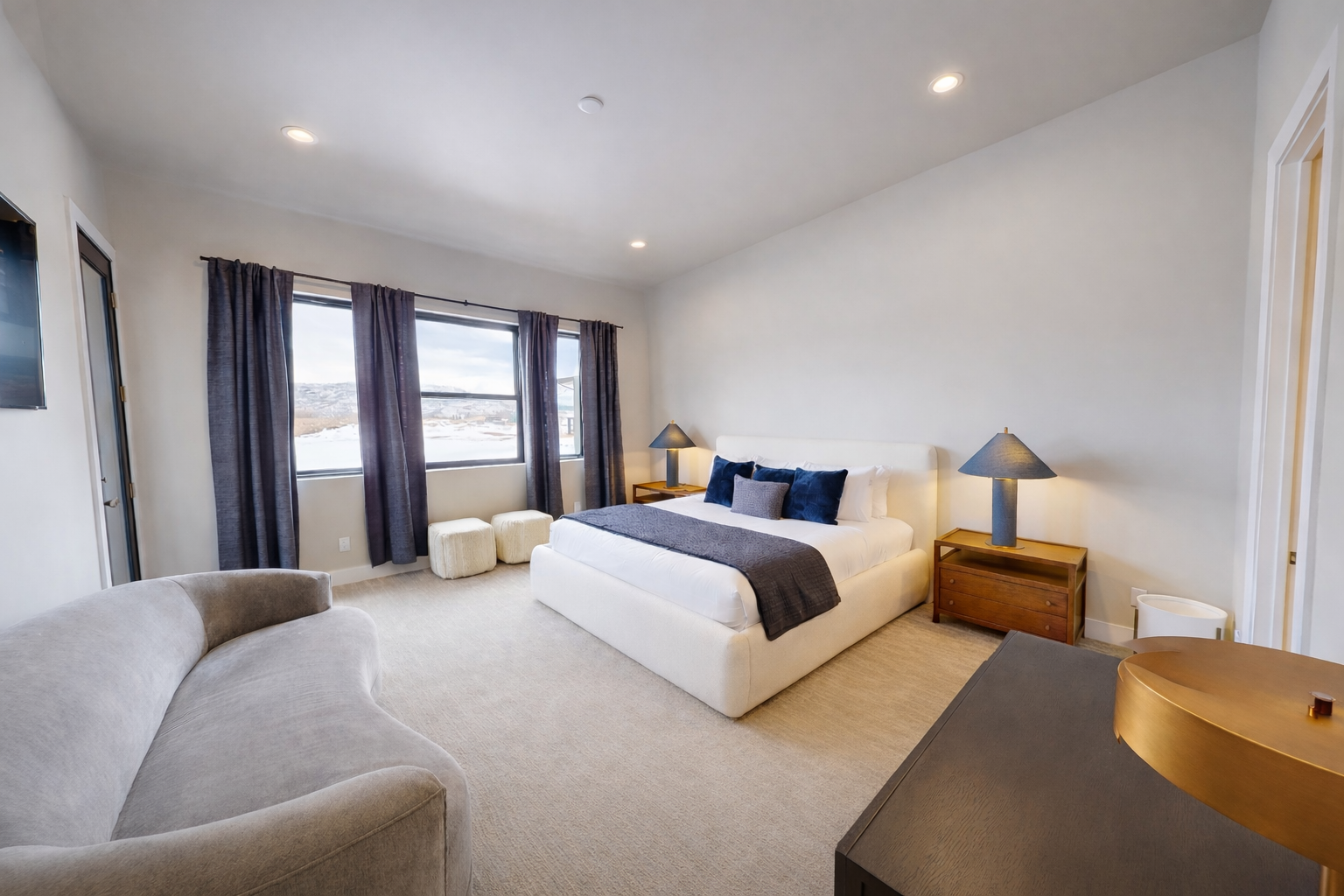 Unwind in your spacious master suite with plush furnishings, warm lighting, and scenic views through expansive windows.