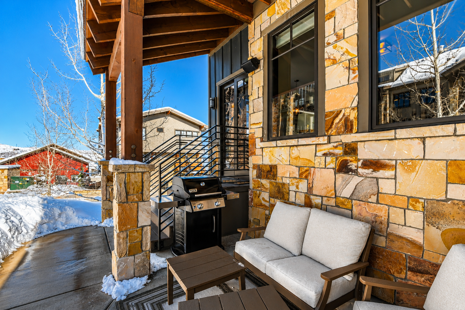 Unwind on this private, stone-accented patio featuring comfortable seating and a professional gas grill. A serene outdoor retreat perfect for mountain-view après-ski or a quiet summer BBQ.