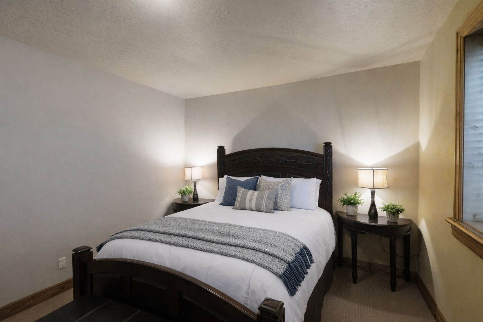 Sink into crisp white linens and plush pillows in your serene bedroom, where soft lighting and thoughtful touches create the perfect retreat.