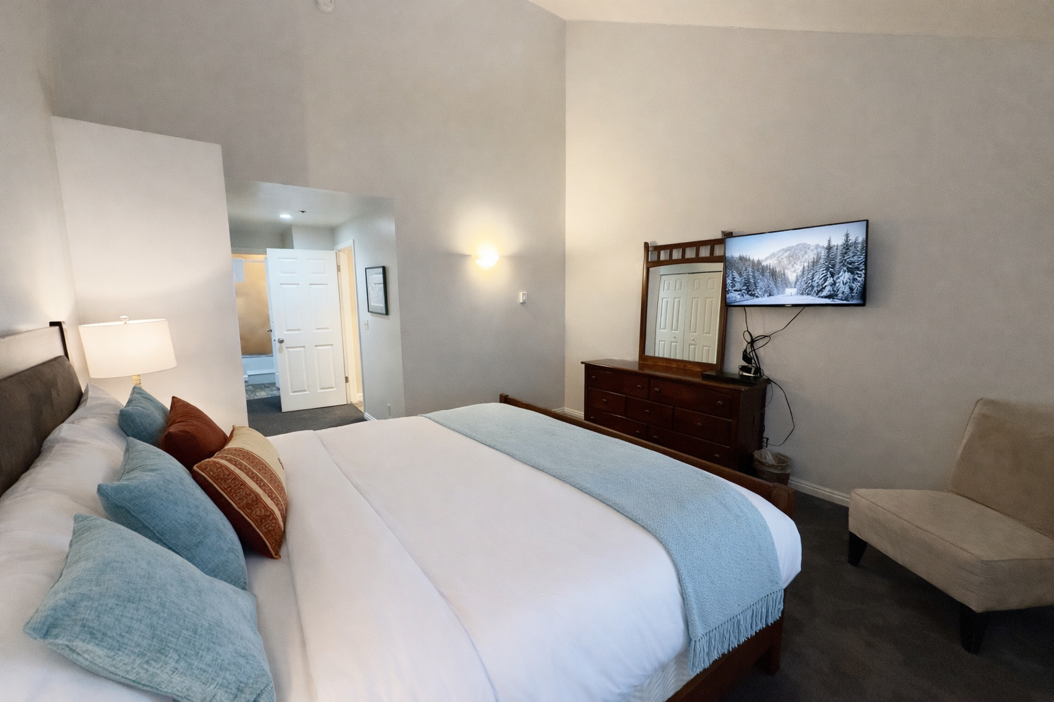 Peaceful guest bedroom featuring a comfortable bed, ceiling fan, and lovely artwork. A tranquil retreat for a restful stay in the mountains.