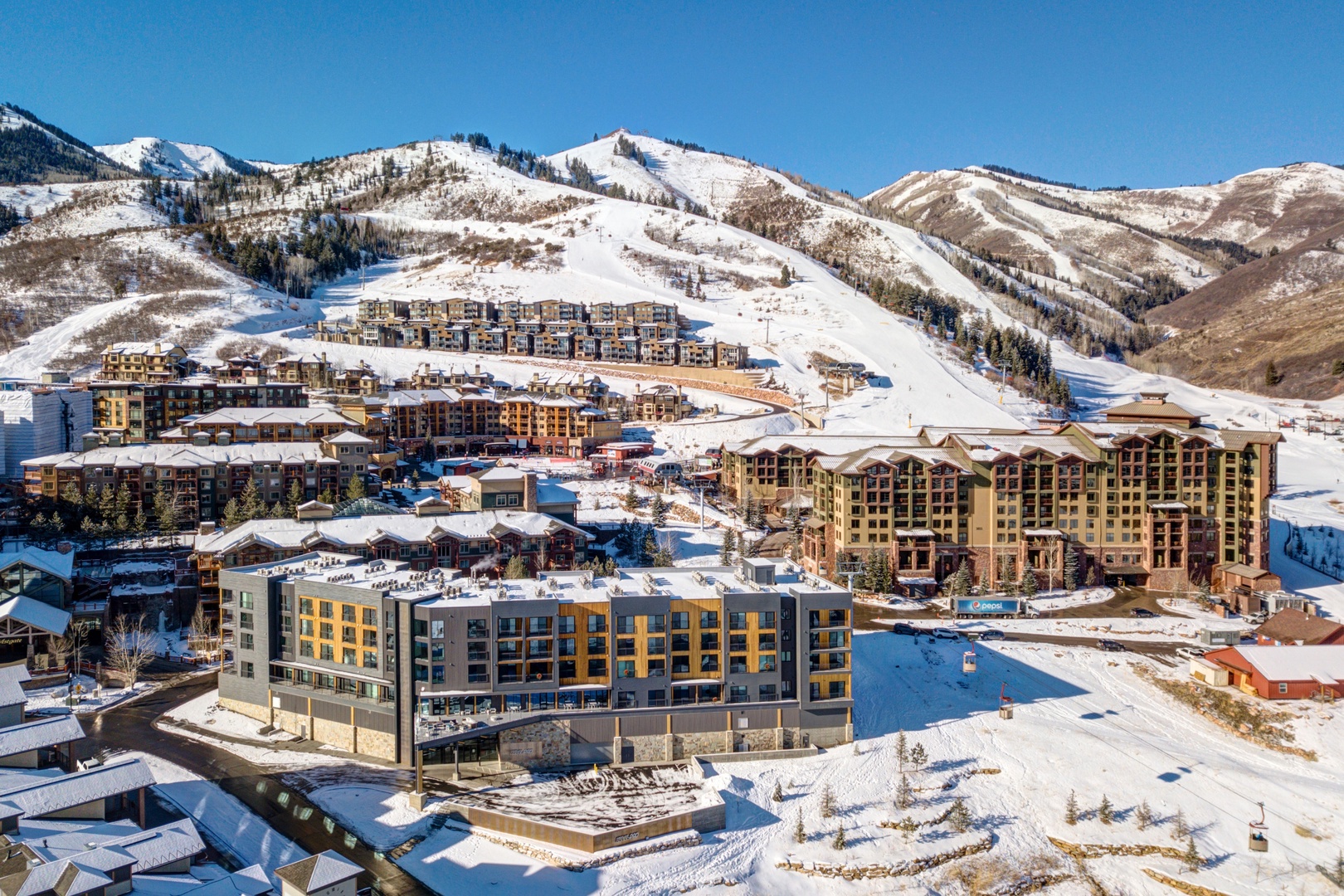 Mountain ski resort village surrounded by snow-covered peaks and ski slopes during winter season.