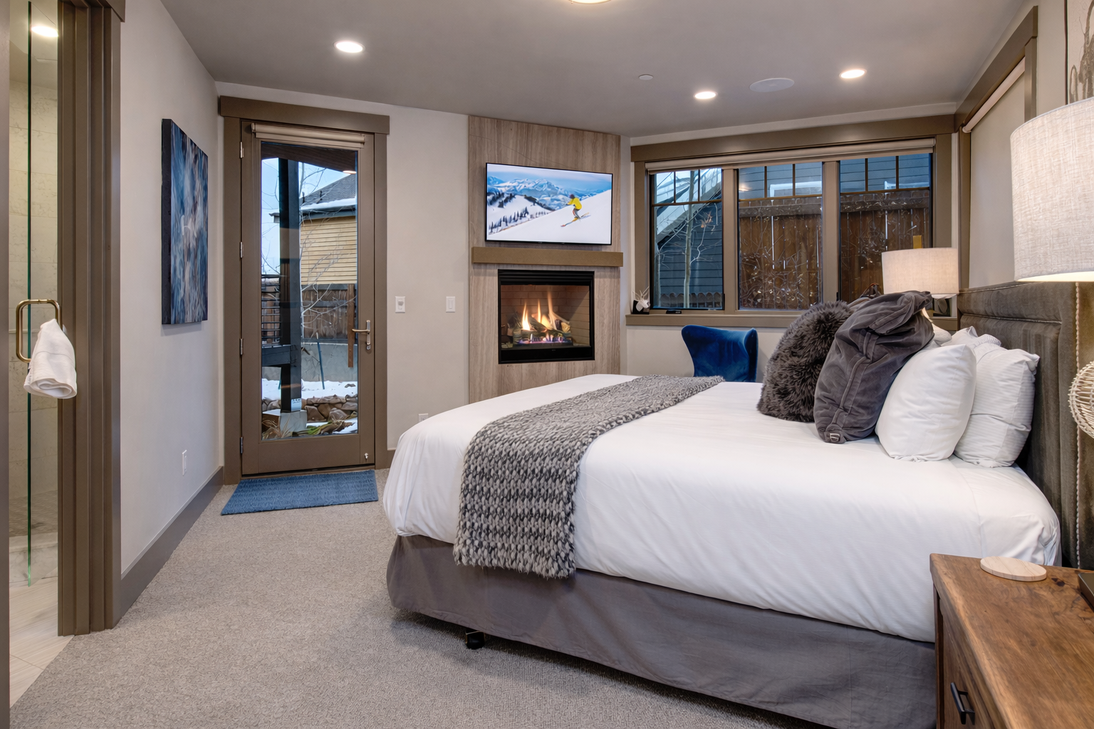 Your luxurious bedroom sanctuary features a cozy fireplace, plush bedding, and private balcony access for ultimate comfort after mountain adventures.