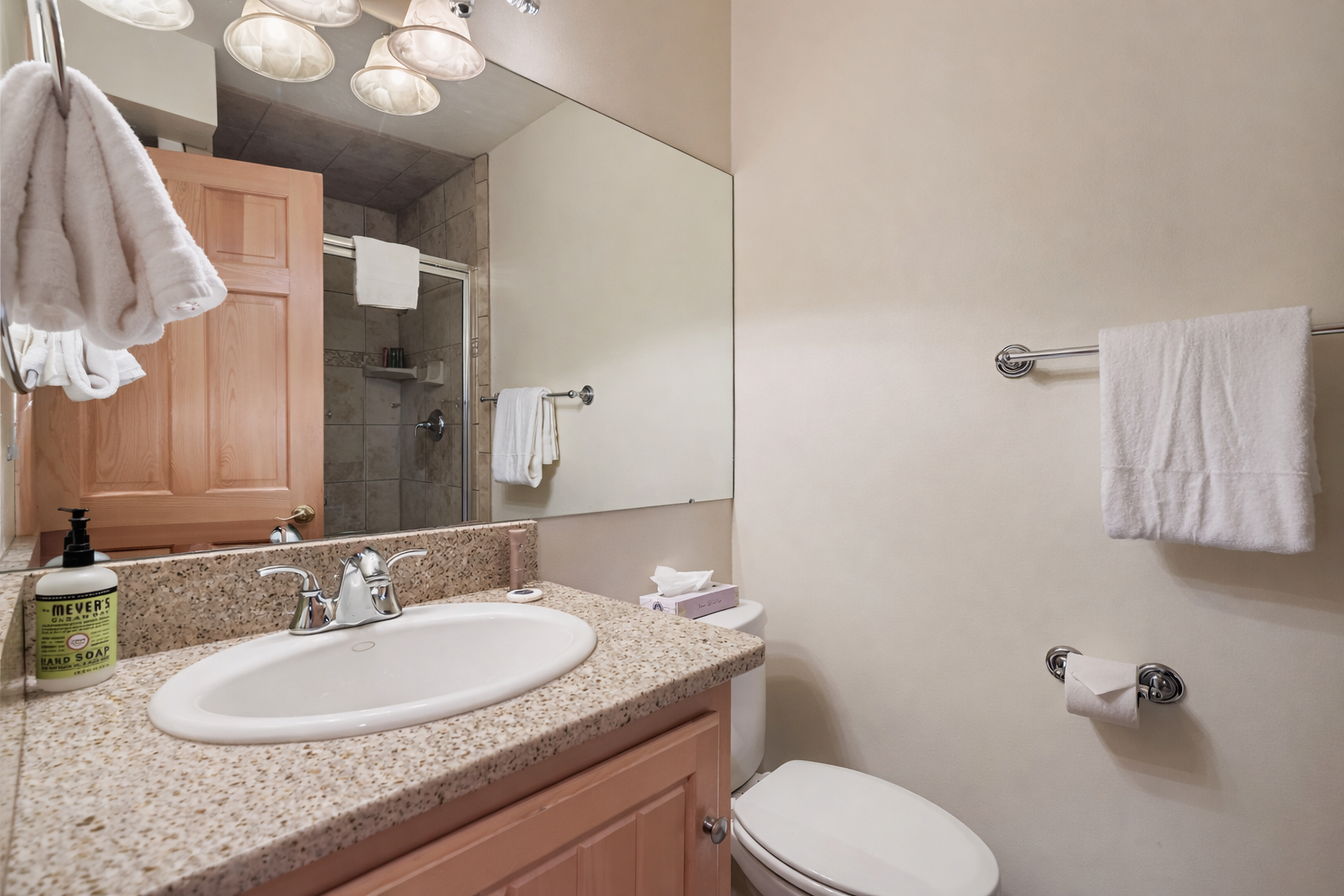 Your private bathroom features fresh white towels and a granite countertop, with a convenient tub-shower combo for relaxing soaks or quick refreshes.