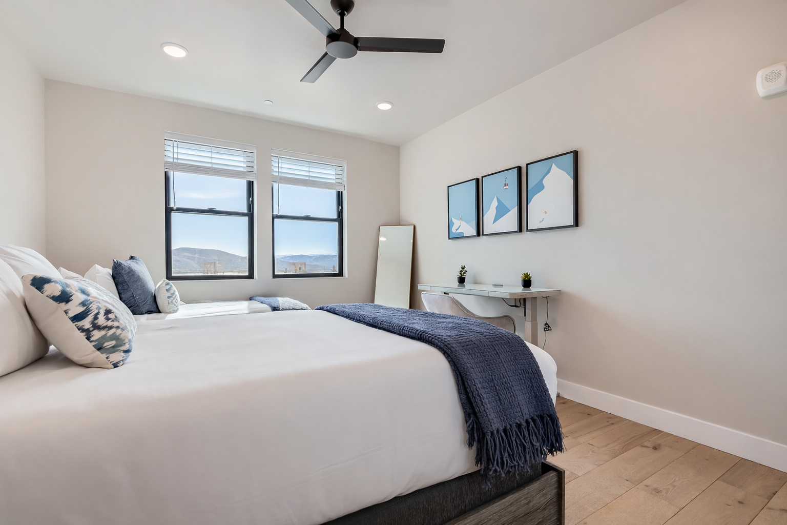 Relax in this bright, modern bedroom featuring two cozy beds with rustic wood frames. Sun-drenched and airy, it’s the perfect spot to rest and recharge after a day of exploring.
